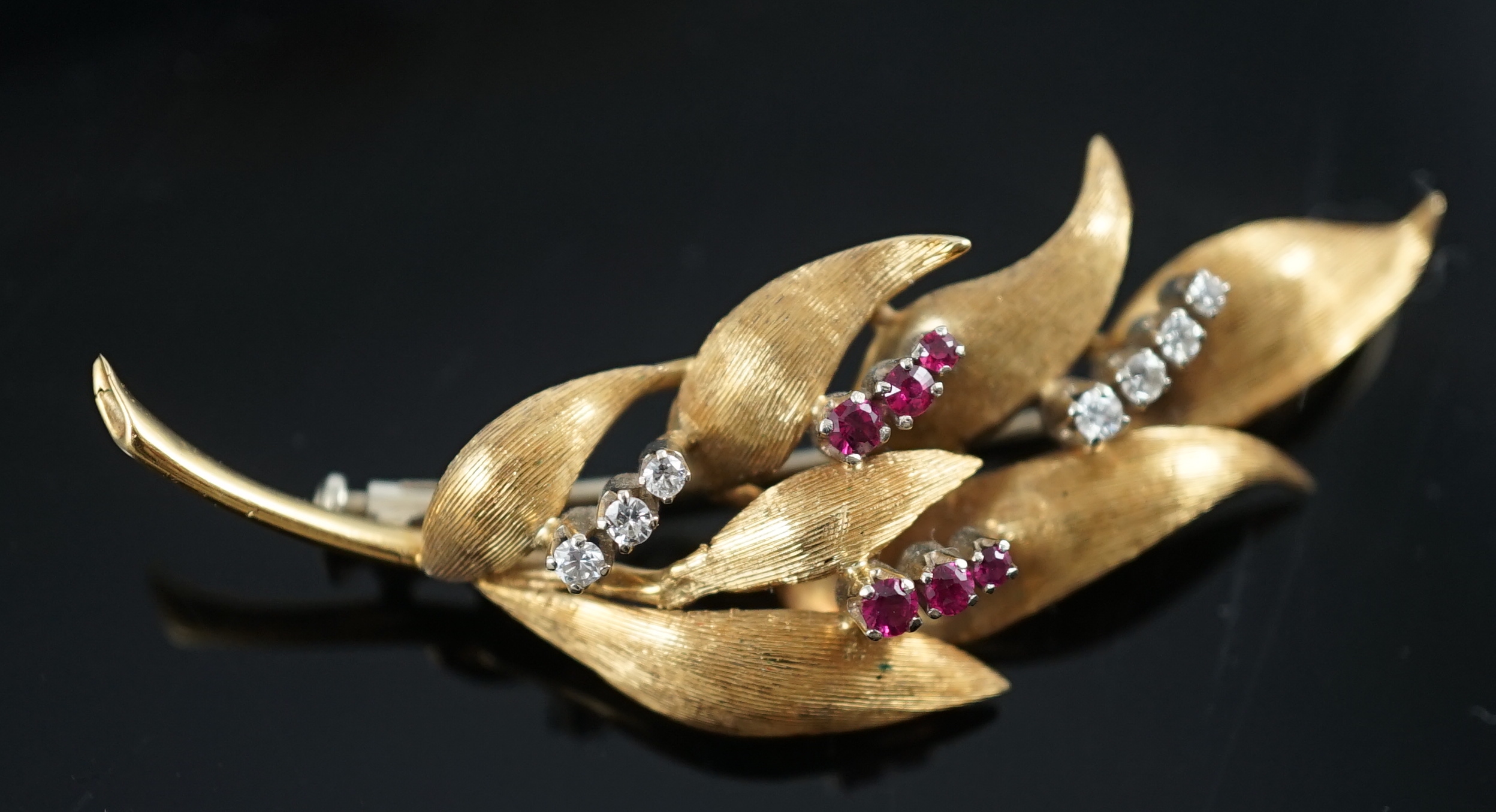 A 1960's 18ct gold, six stone ruby and seven stone diamond chip set leaf spray brooch